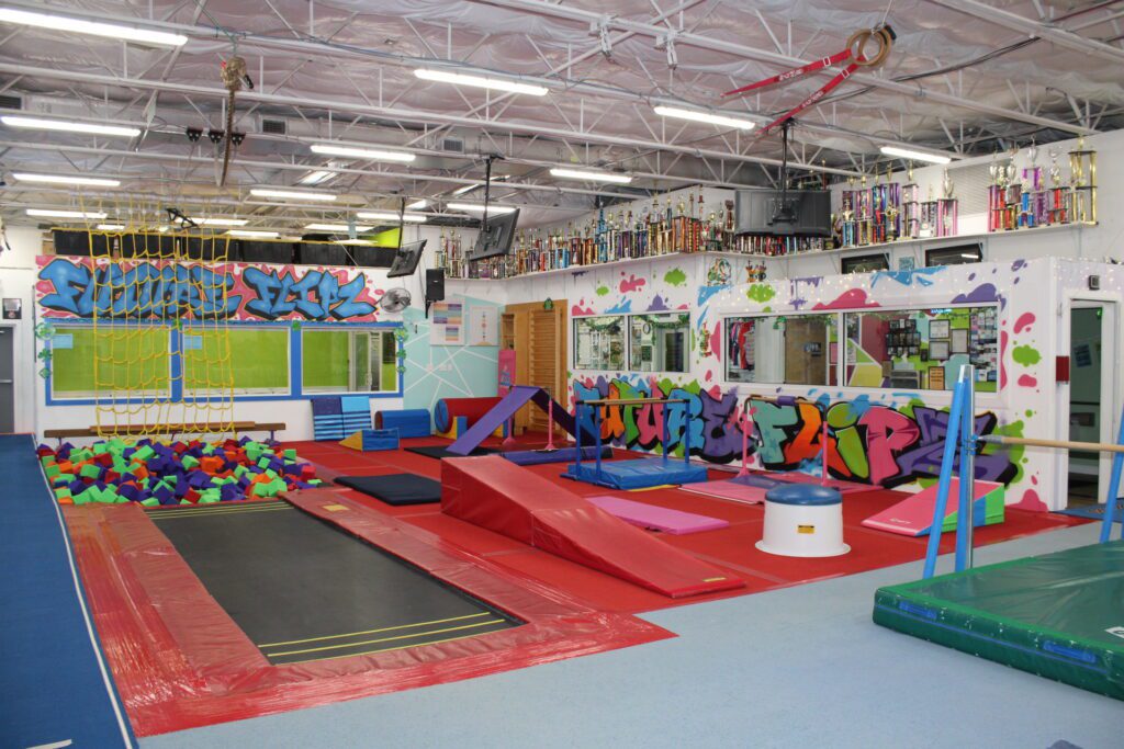 Indoor trampoline and foam pit area with colorful graffiti walls.